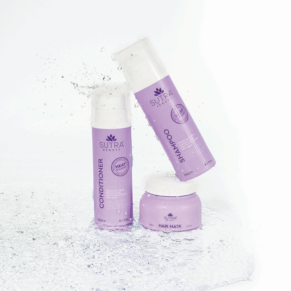 Sutra heat guard products - conditioner, shampoo, and hair mask - in light purple packaging, placed on a white floor with water around
