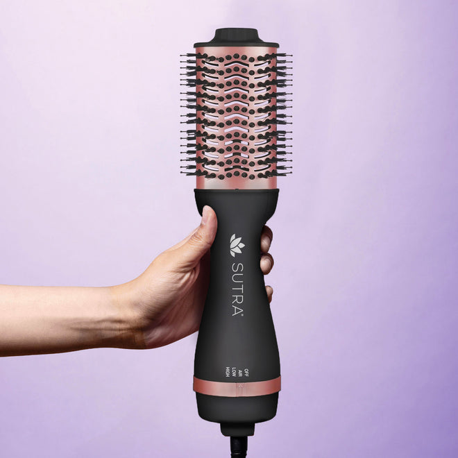 hand-holding-rose-gold-and-black-2-inch-professional-blowout-brush