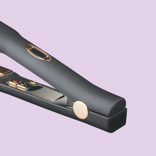 a close-up image of a black flat iron with gold details, with a plate measuring one and a half inches, and a digital display