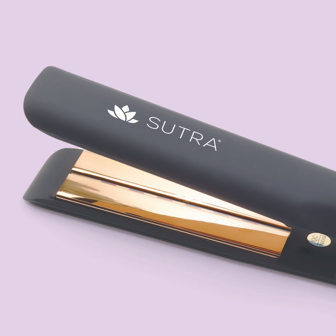 A close-up image of a black flat iron and gold color plate tool with the white SUTRA logo